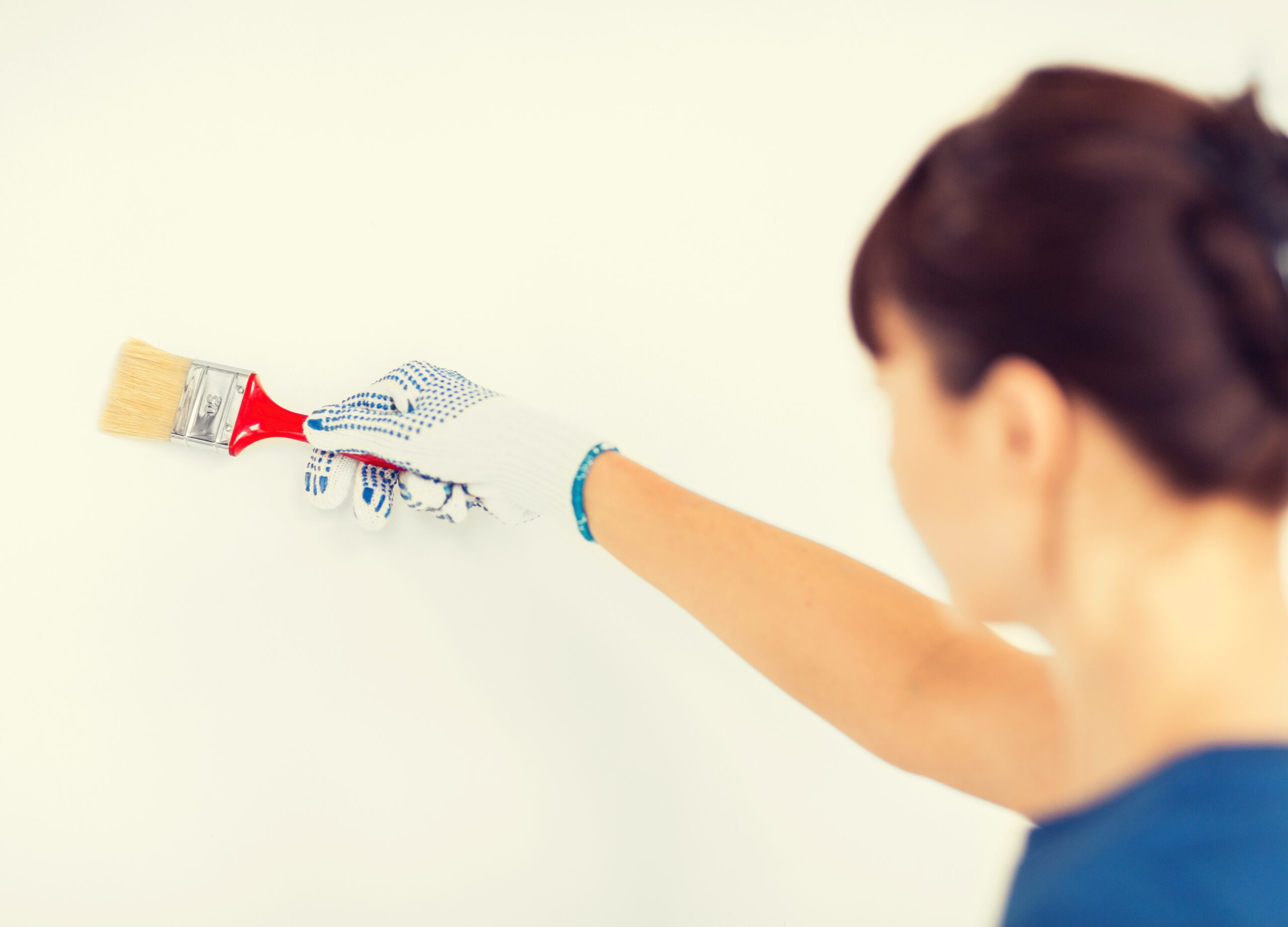 woman with paintbrush colouring the wall